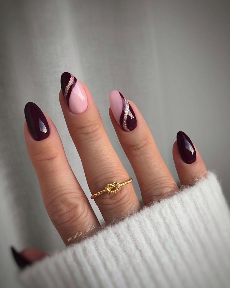 Chic Elongated Nail Design in Deep Burgundy and Soft Pink with Shimmering Details and a Gold Ring.