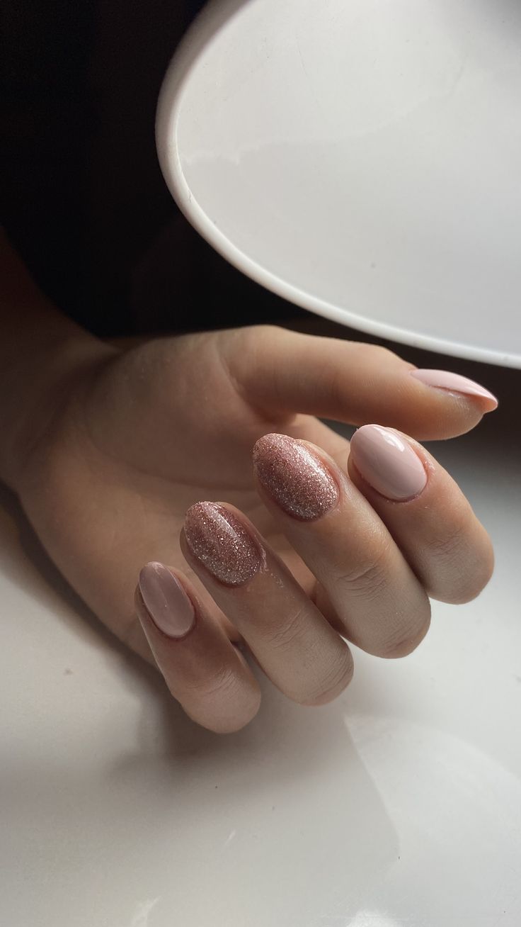 Chic Soft Pink Nail Design with Shimmer and Glitter Accents.