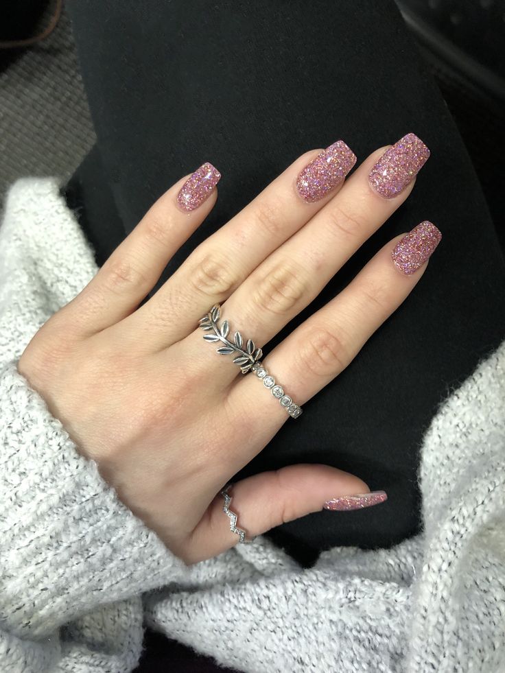 Striking Soft Pink Glitter Nails: Elegant Statement with Complementing Rings.