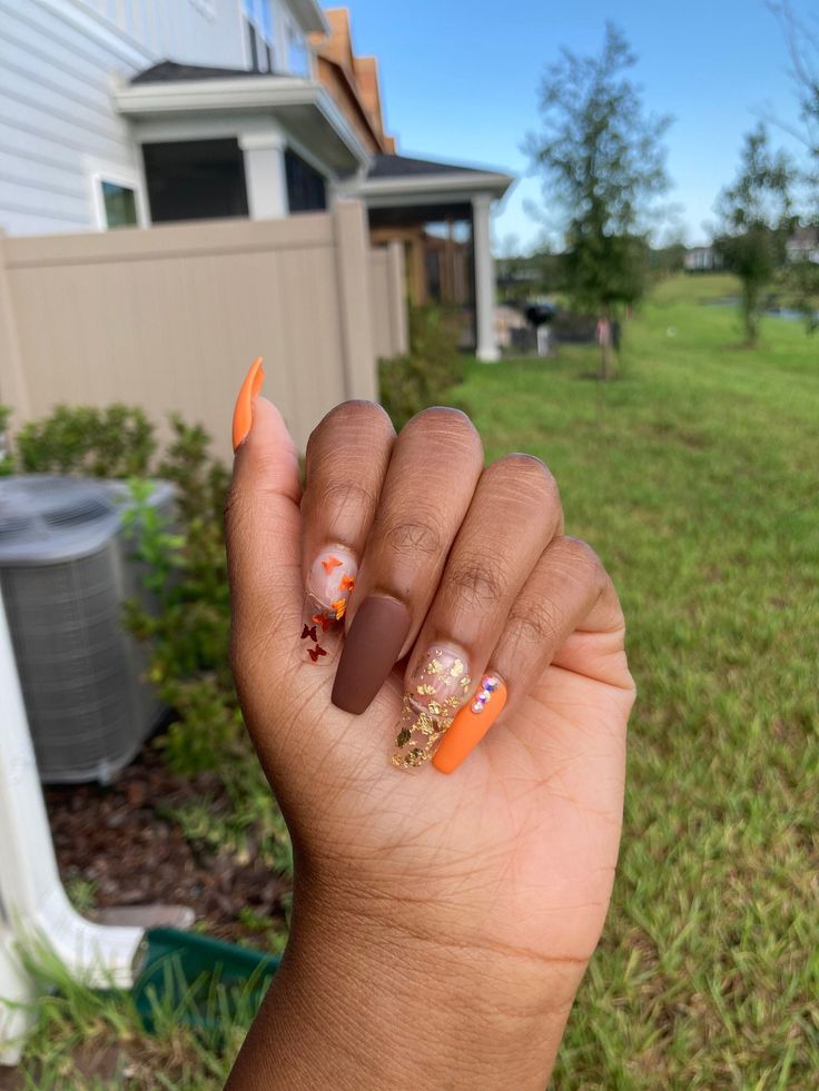 Autumn-Inspired Manicure with Warm Colors and Glittery Star Accents.