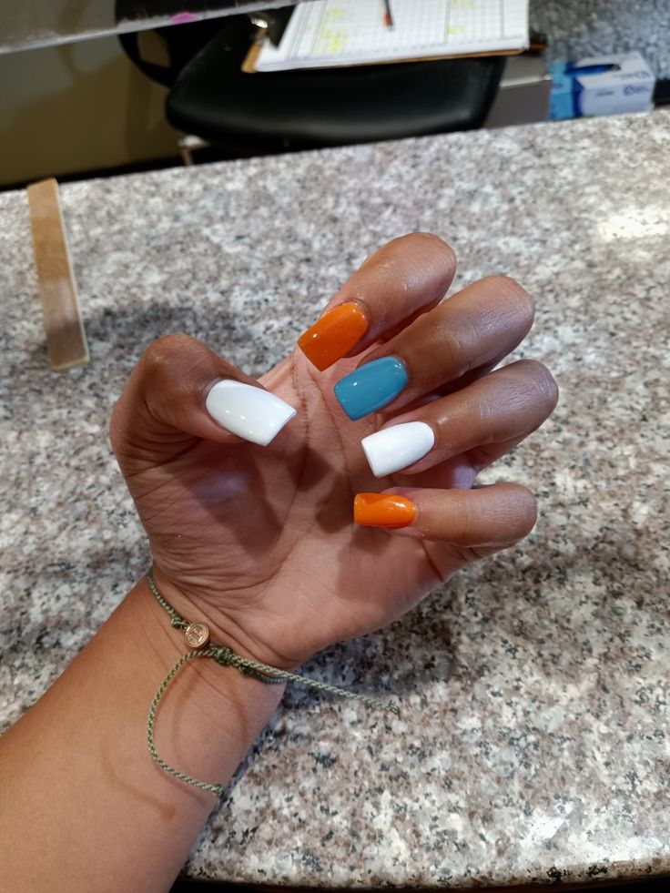 Playful Colorful Nail Design with Bright Orange, Refreshing Turquoise, and Crisp White.