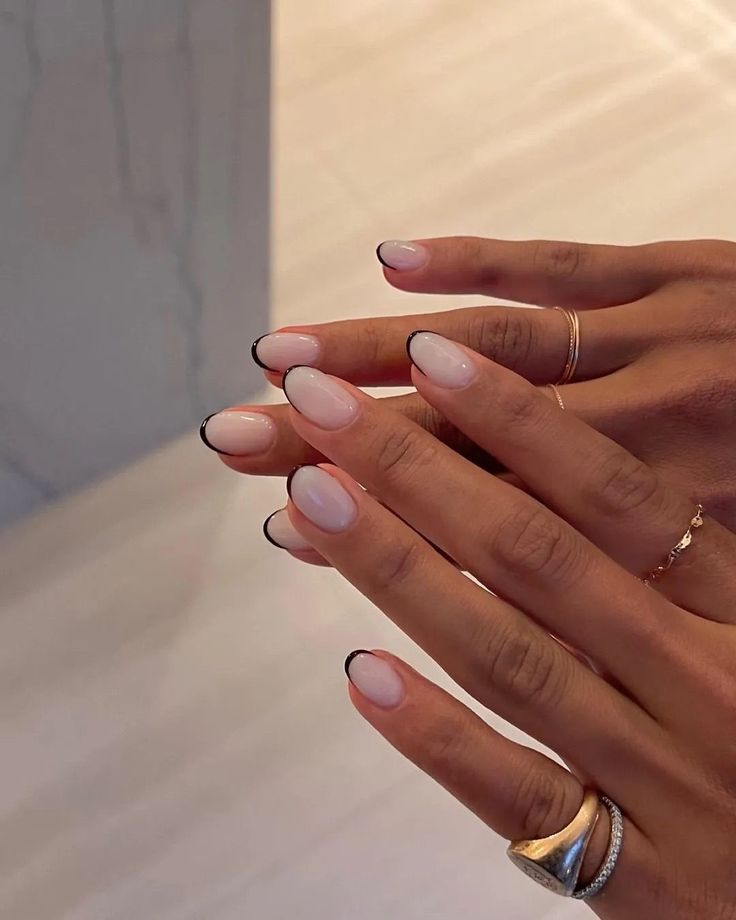 Chic Almond-Shaped Nails: Soft Nude Base with Elegant Black Tips