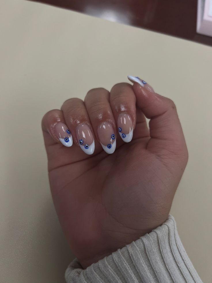 Elegant French Tip Nail Design with Blue Dots.