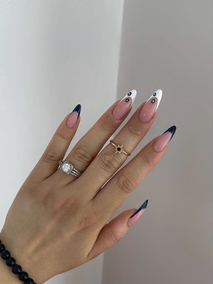 Elegant Stiletto Nail Design: Nude, White, and Navy with Chic Accents.