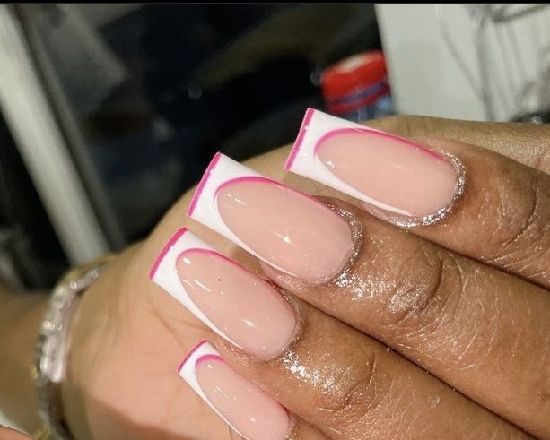 Trendy French Tip Acrylic Nails with Vibrant Pink Accents and Shimmering Cuticle Detail.