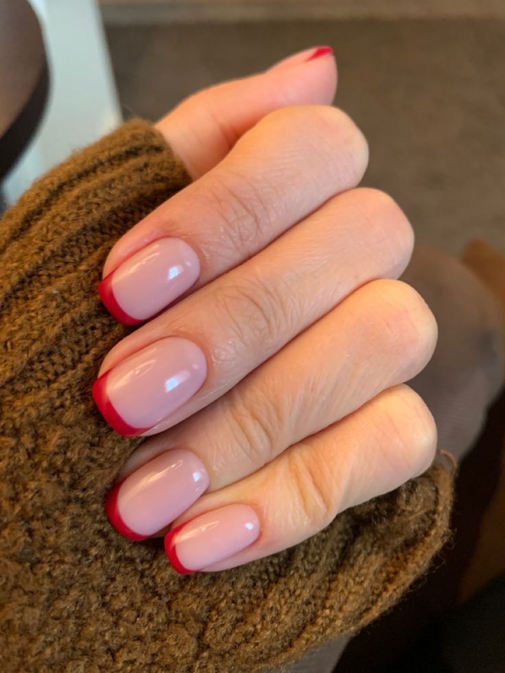 Chic Soft Pink and Red-Tipped Nails: A Modern Twist on the Classic French Manicure.