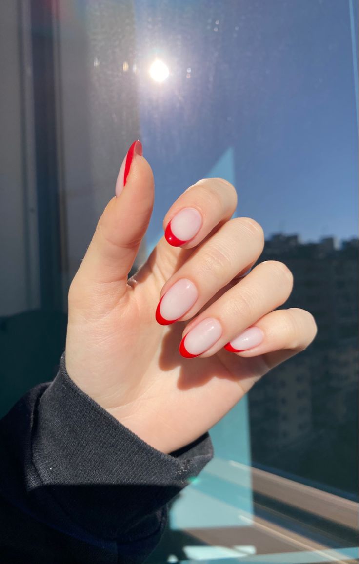 Elegant Red French Tips on Soft Nude Base: A Chic Nail Design for Any Occasion.