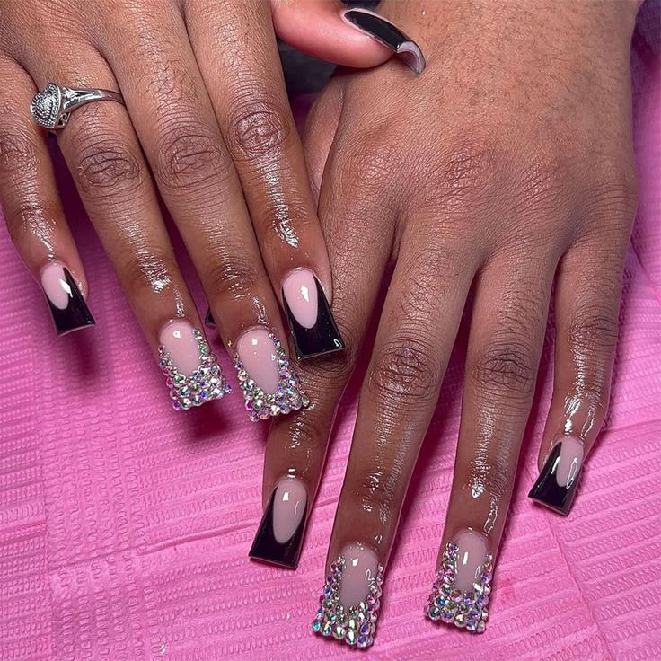 Chic Nail Design: Long Square Tips with Soft Pink Base, Black Accents, and Sparkling Rhinestones.