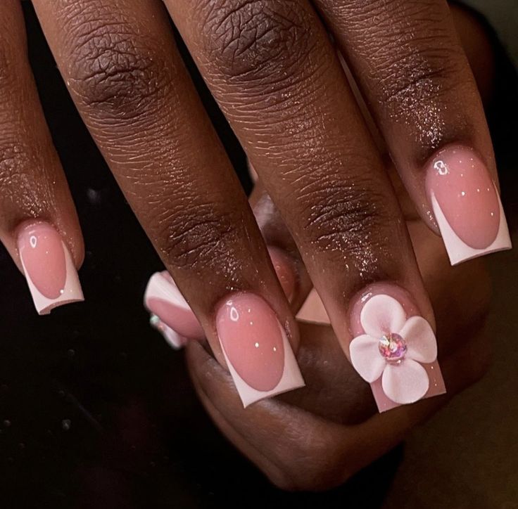 Chic Soft Pink Nail Design with Floral Accent and Sparkling Gems.