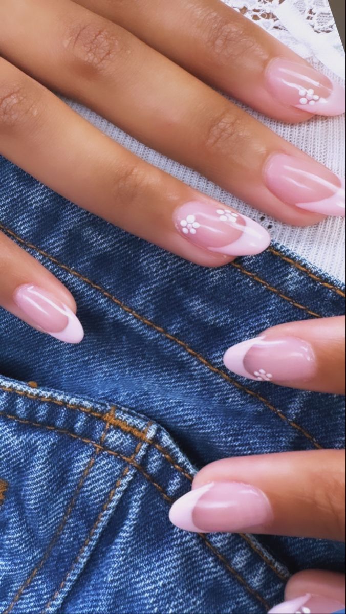 Stylish Soft Pink Nails with Elegant French Tips and Whimsical Floral Accents.