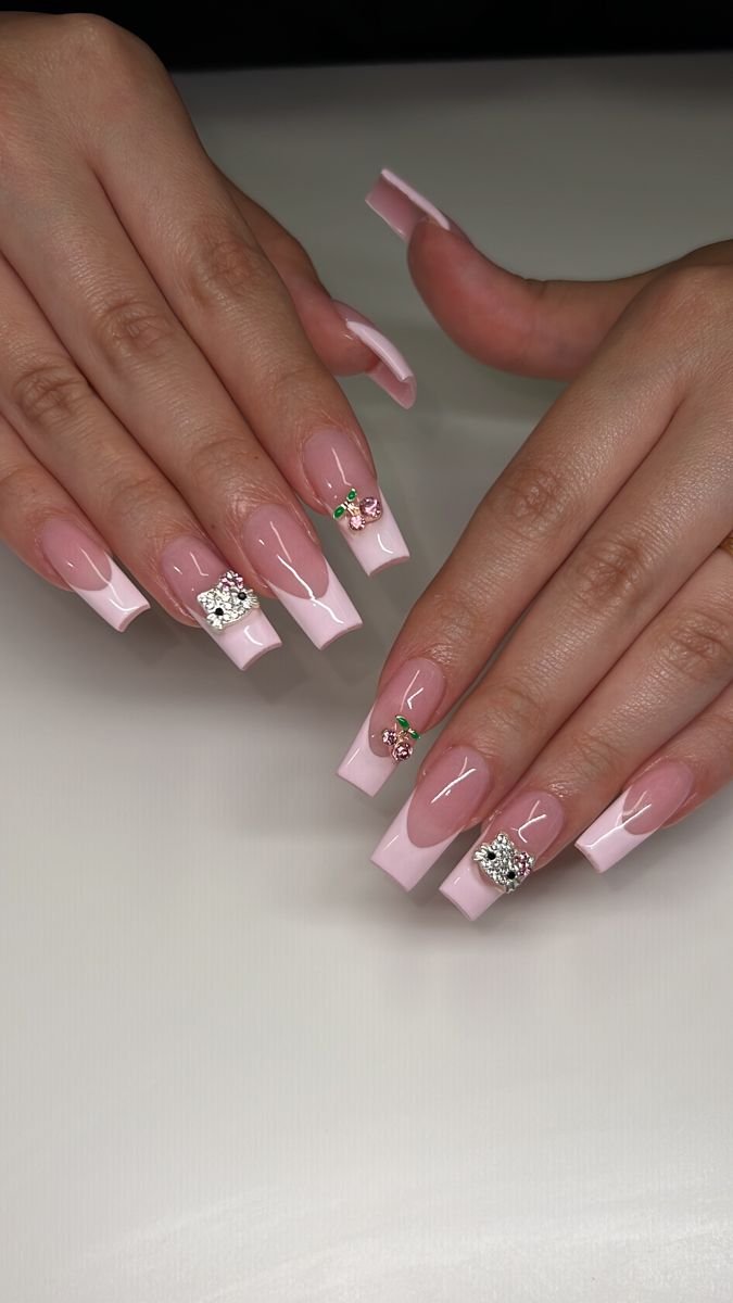 Chic Soft Pink Nail Design with Glamorous Embellishments and Floral Motifs.