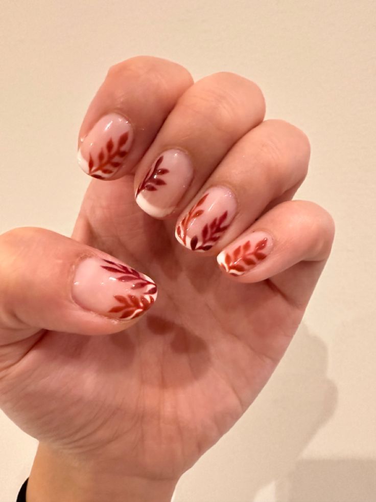 Autumn-Inspired Elegant Nail Design with Delicate Leaf Patterns and Warm Accents.