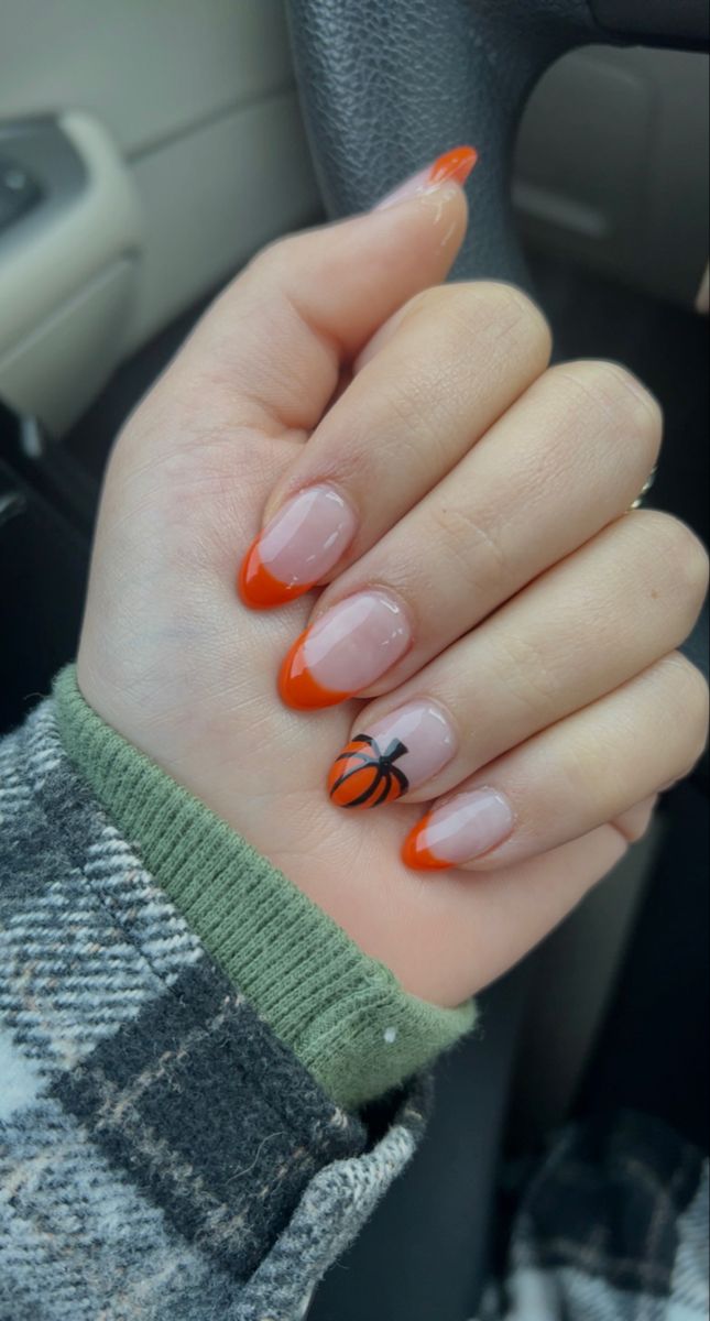 Chic Autumn Nail Design: Playful Orange Tips with Whimsical Black Accents.