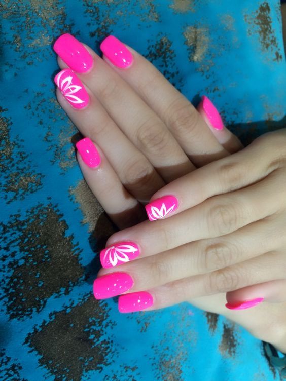 Vibrant Pink Nails with Intricate White Floral Designs for a Playful and Chic Look.