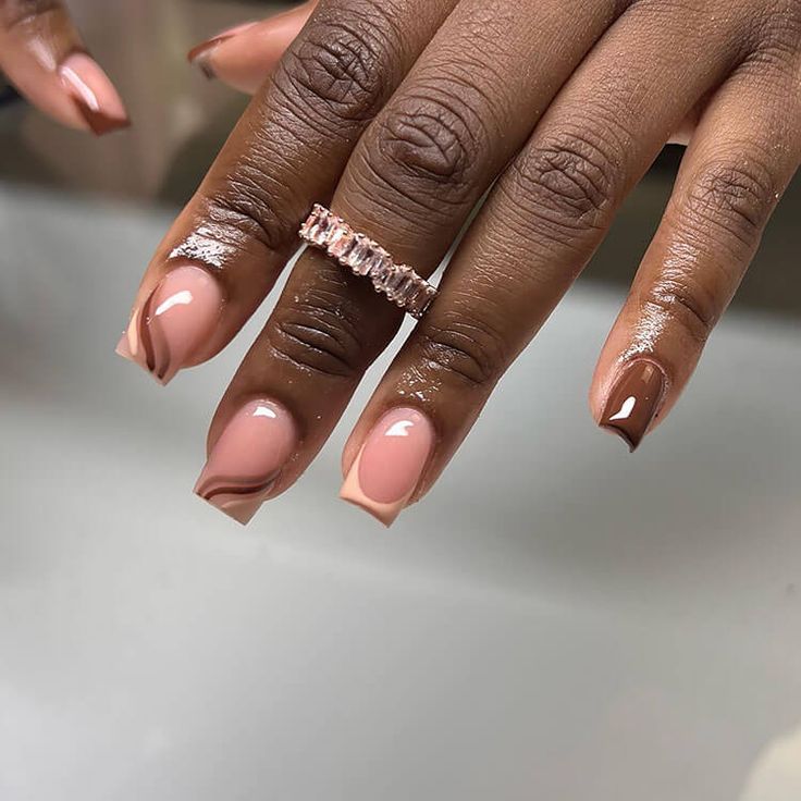 Sophisticated Nail Design with Nude and Earthy Tones, Glossy and Matte Finishes, Trendy Abstract Swirls, and Elegant Ring Accents.