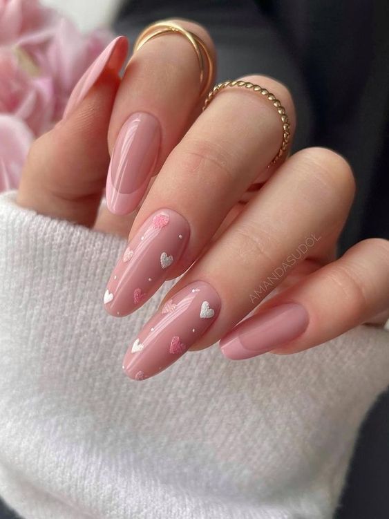 Elegant Soft Pink Almond-Shaped Nails with Delicate Heart Patterns for a Romantic Touch.