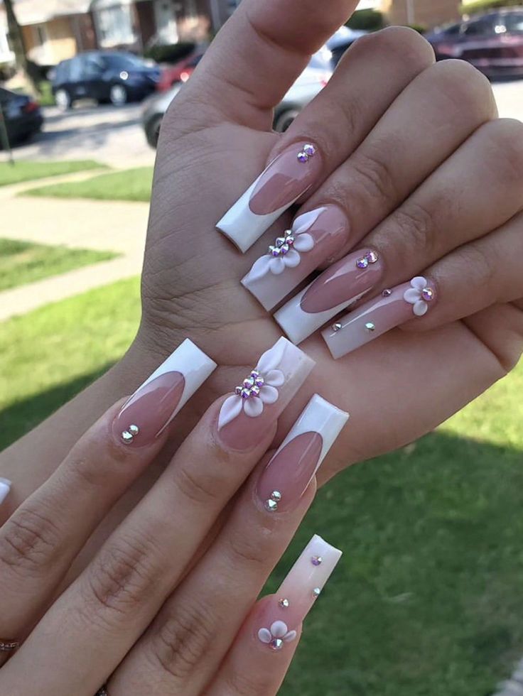 Chic Nude and White Nail Design with Floral Accents and Rhinestones