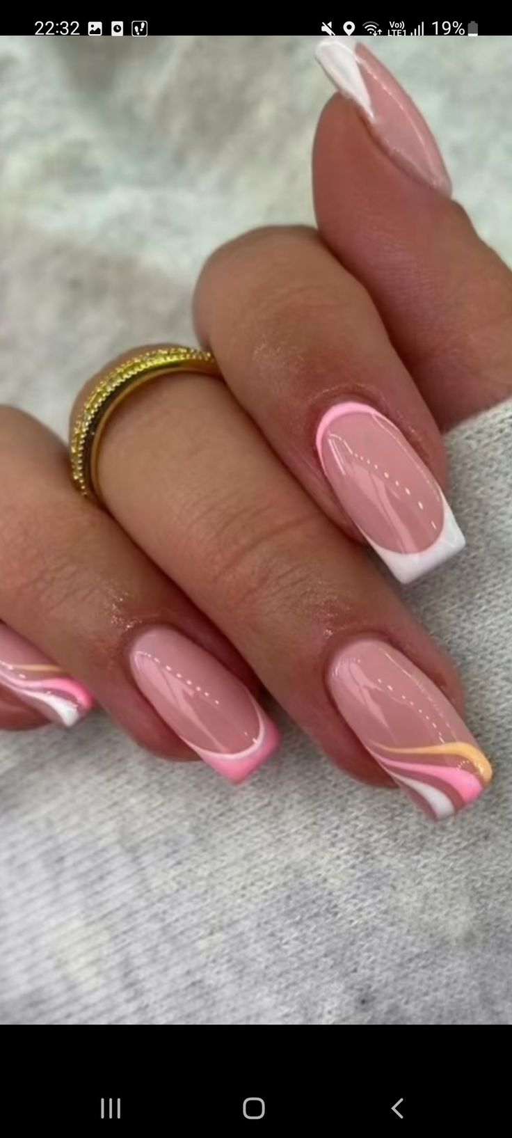 Chic Soft Pink French Manicure with Delicate Pink and Gold Accents.