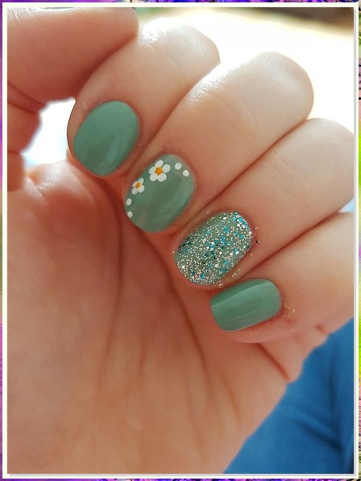 Whimsical Mint Green Nail Design with Glitter Accents and Floral Details for Spring/Summer.