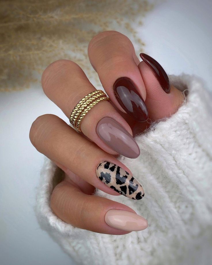 Chic Nail Design: Sophisticated Muted Tones and Bold Patterns with Playful Leopard Accent.