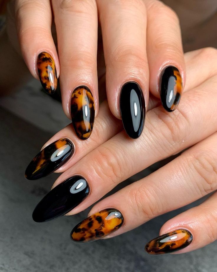 Chic Almond-Shaped Nail Design: Glossy Black and Warm Tortoiseshell Elegance.