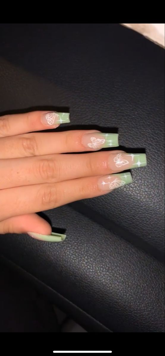 Whimsical Soft Green Nail Design with Intricate White Butterfly Patterns on Squared Tips