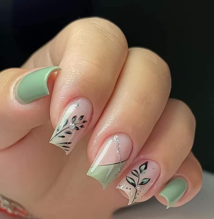 Sophisticated Pastel Green and Nude Nail Design with Intricate Leaf Patterns and Chic Finishes.