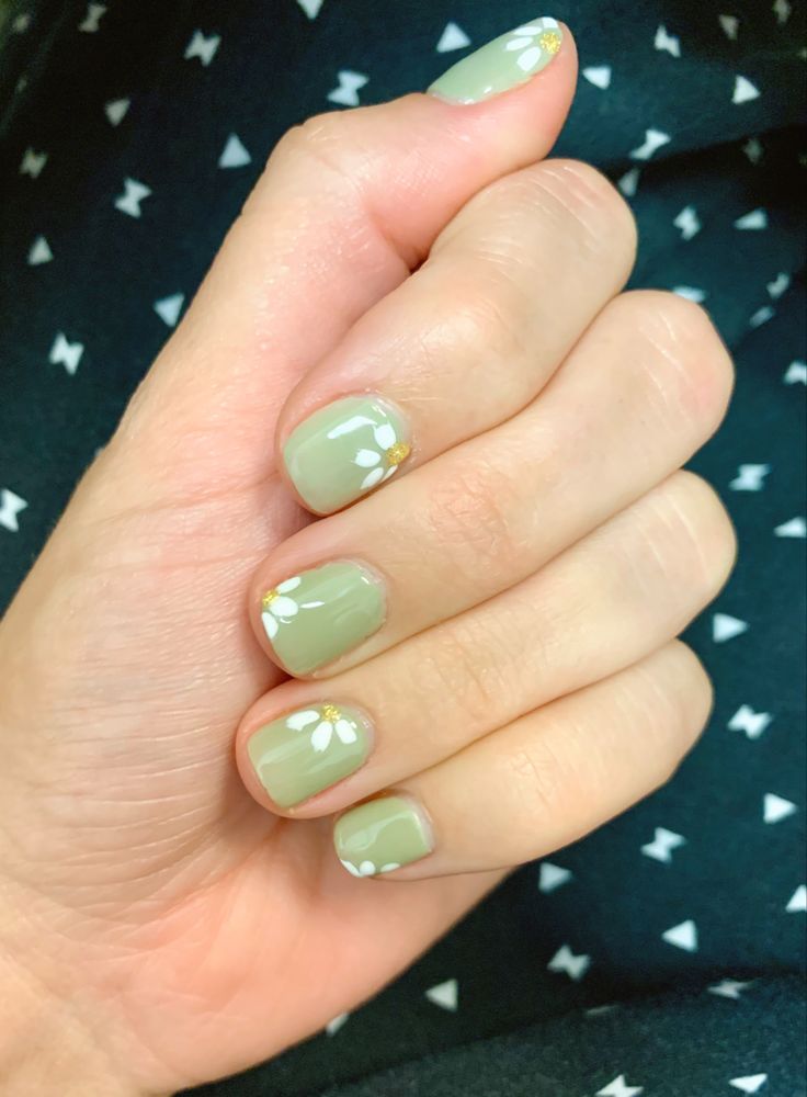 Elegant Spring-Inspired Nail Design with Soft Green Base, Floral Patterns, and Gold Accents