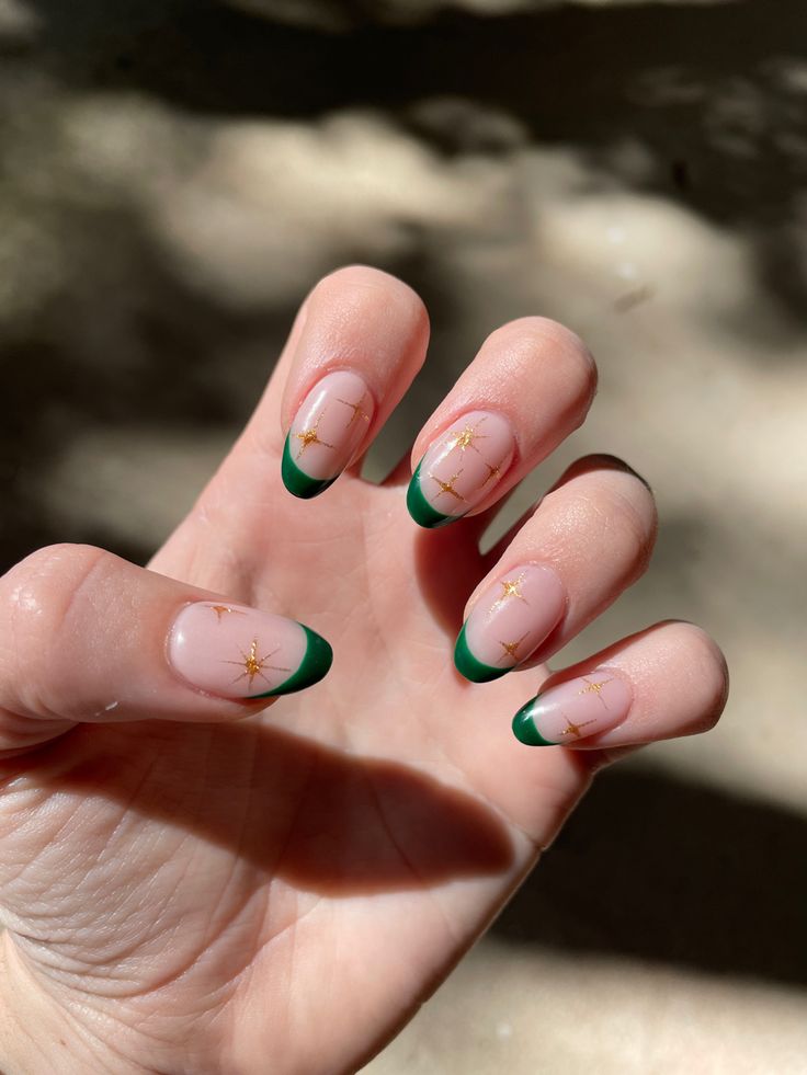 Chic Nail Design: Transparent Base with Bold Green French Tips and Golden Star Accents.