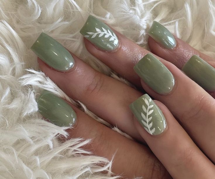 Elegant Green Nail Design with Glossy Finish and Matte Texture, Accented by Delicate White Leaf Patterns for a Sophisticated, Trendy Look.