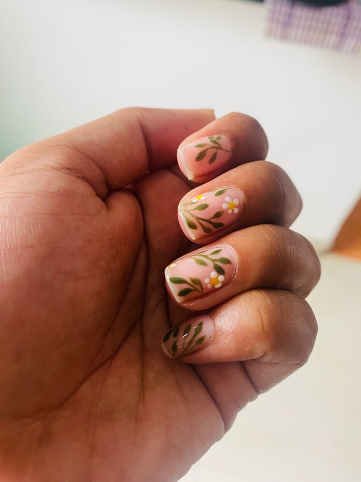 Charming Floral Nail Design with Delicate Greenery and White Flowers on Soft Pink Base