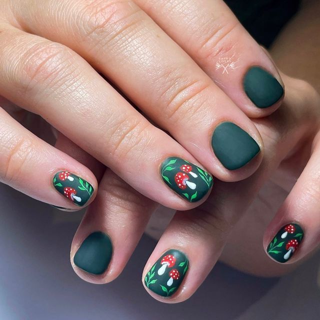 Elegant Deep Green Matte Nail Design with Intricate Red Floral Artwork.