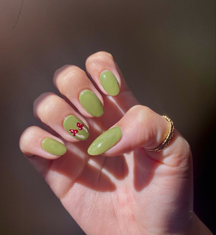 Charming Green Almond-Shaped Nails with Glossy Finish and Whimsical Red Flower Design.