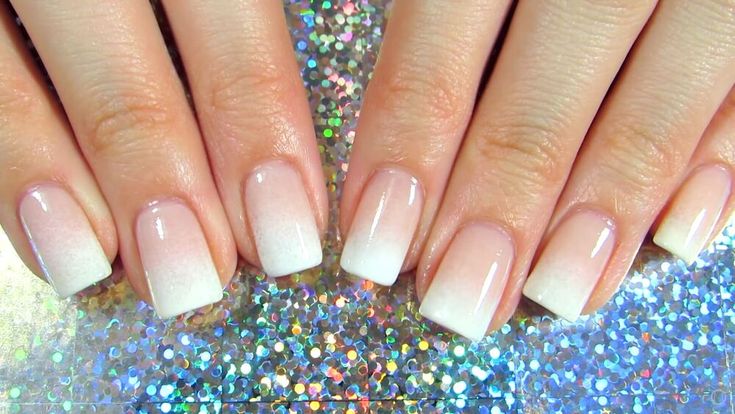 Elegant Ombre Nail Design: Soft Nude to White Gradient with Glossy Finish and Sparkling Background.