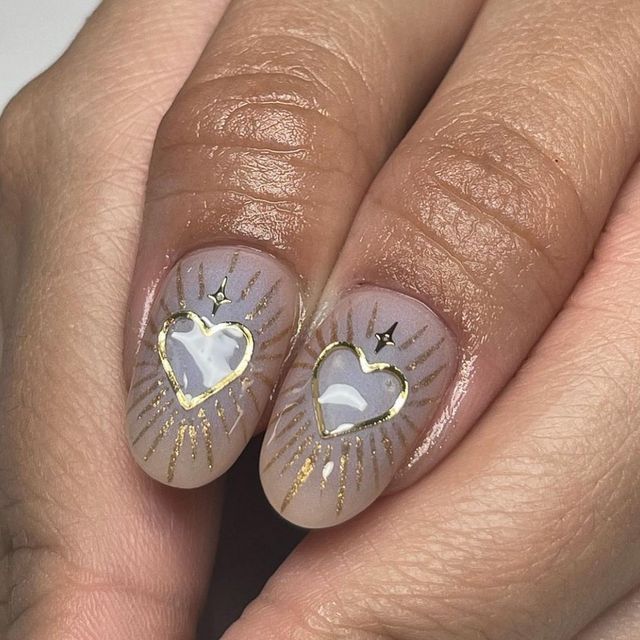 Elegant Heart Motif Nail Design with Gold Outlines and Sunburst Accents