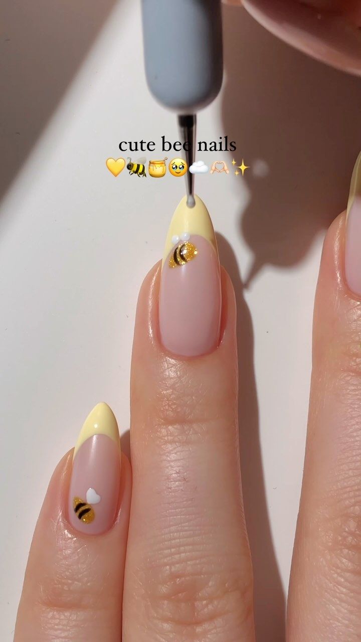 Cheerful Bee-Inspired Nail Design: Soft Pink with Yellow Tips and Delicate Motifs.