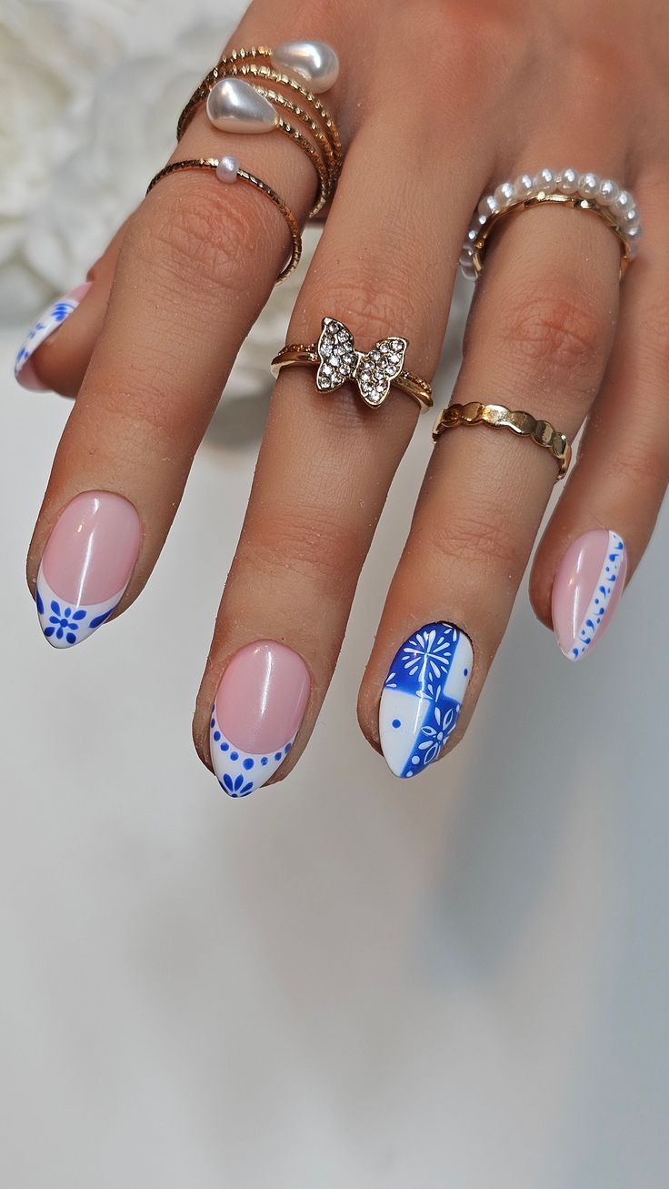 Sophisticated Nail Art: Elegant French Tips in Soft Pink and Vibrant Blue with Floral and Geometric Patterns.