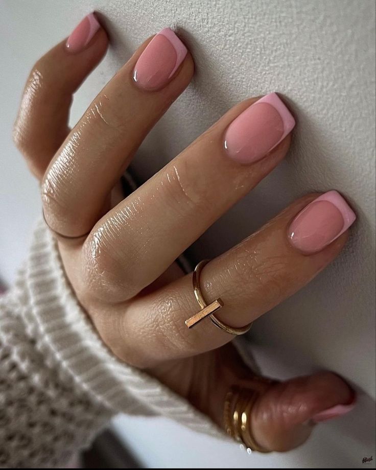 Sleek Soft Pink and White Tip Nail Design with Glossy Finish and Delicate Ring Accents.