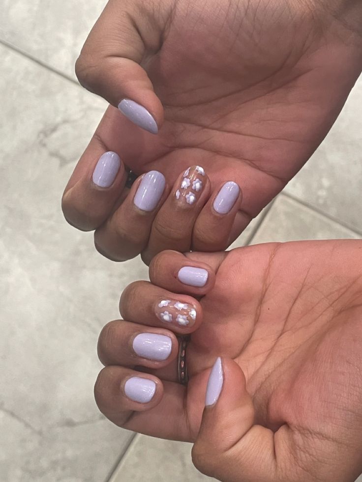 Delicate Pastel Lavender Nails with Floral Accent: A Perfect Blend of Simplicity and Artistry.