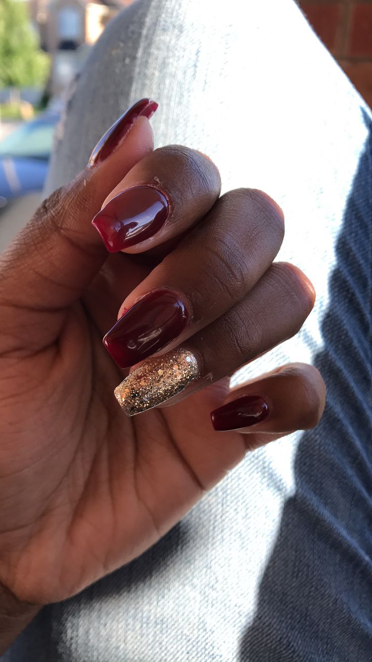 Sophisticated Deep Burgundy Manicure with Striking Gold Glitter Accent