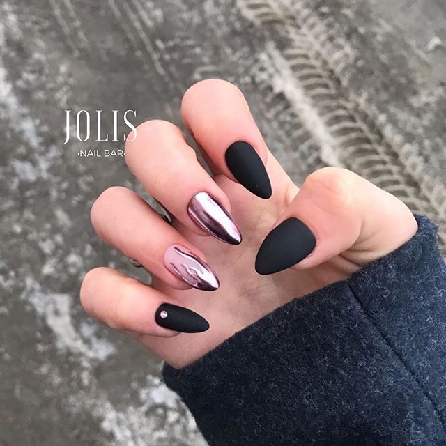 Chic Almond-Shaped Nail Design with Matte Black, Glossy Metallics, and Subtle Gem Accents.