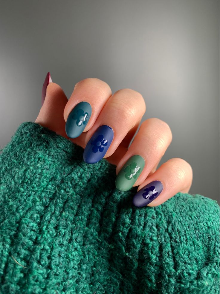 Chic Matte Nail Design with Blue-Green Gradient and White Floral Accents.