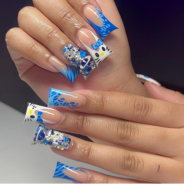 Playful Blue and White Nail Design with Intricate Patterns and Glamorous Gemstones.