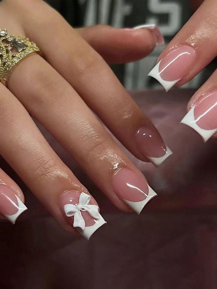 Elegant Nude and White French Tip Nail Design with Charming Bow Embellishment