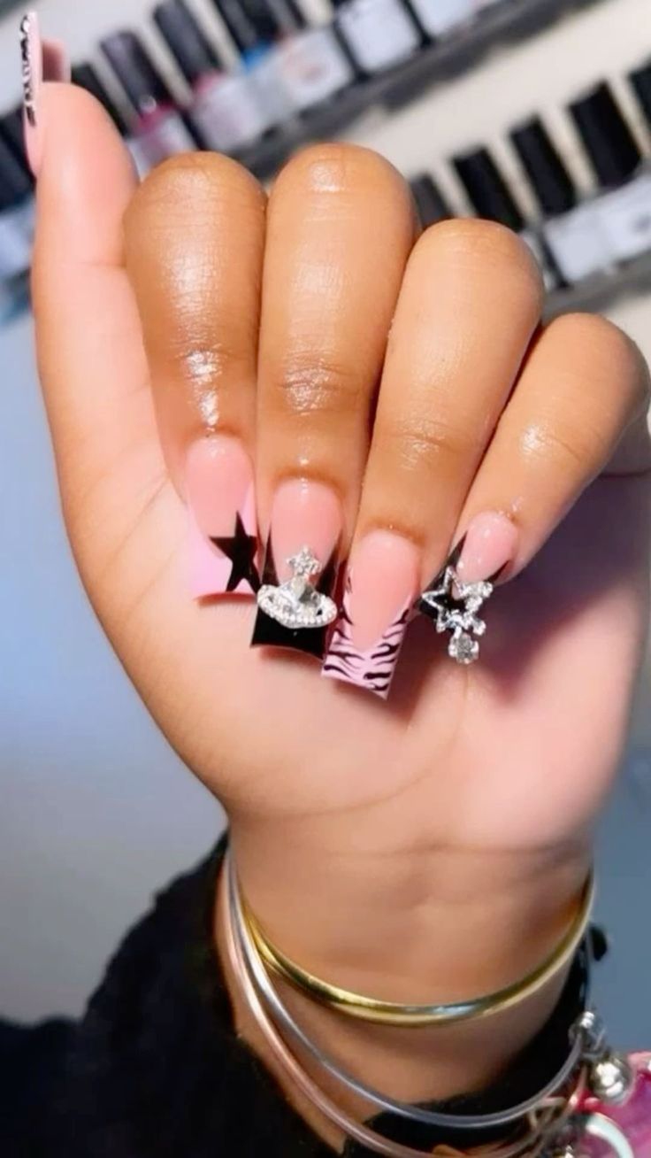 Chic Pastel Pink and Bold Black Nail Design with Glitter and Zebra Print Accents.