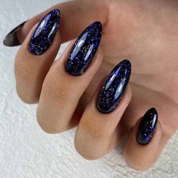 Cosmic Galaxy-Inspired Nail Design with Shimmering Holographic Glitter on Almond Shapes.