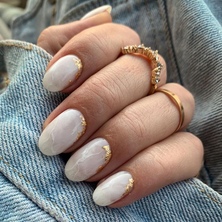 Sophisticated Marble Nail Design with Glossy White Base and Golden Accents.