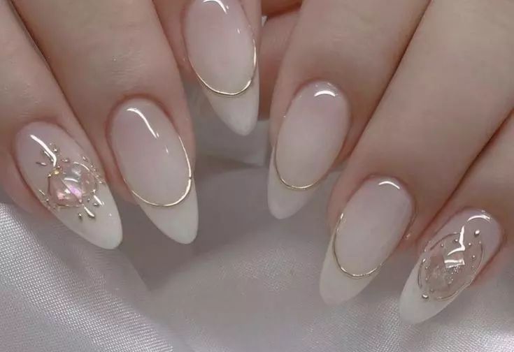 Elegant Almond-Shaped Ombre Nails with Gold Accents and Gems for Sophisticated Glamour.