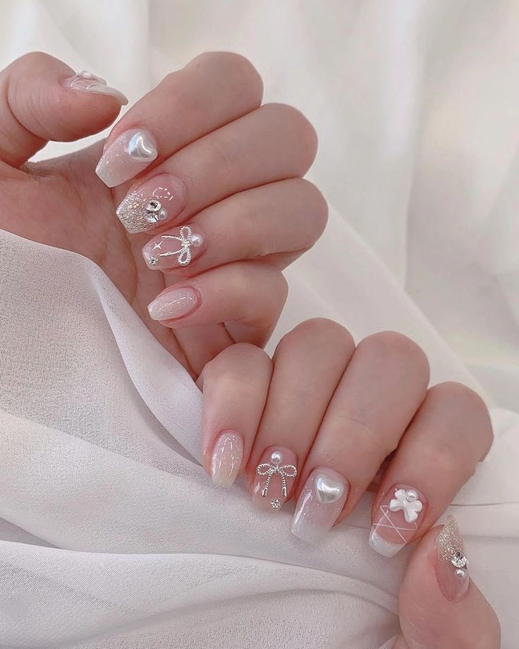 Charming Pastel Nail Design with Intricate Embellishments and Sparkling Accents.