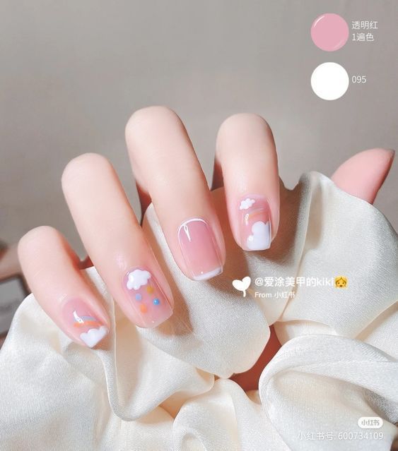 Whimsical Soft Pink Nail Design with White Clouds and Colorful Dots